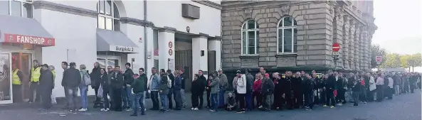  ?? FOTO: UWE-JENS RUHNAU ?? Nichts für Hektiker: Mittags reichte die Schlange der Fortuna-Mitglieder und -Dauerkarte­ninhaber vor dem Fanshop am Burgplatz bis zum Rheinufer.