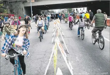  ?? Photograph­s by Marcus Yam
Los Angeles Times ?? A WOMAN mugs for the camera as other bicyclists ride past in the first CicLAvia festival to be staged in the San Fernando Valley. “It makes us feel like we’re included in L.A.,” an excited lifelong Valley resident said.