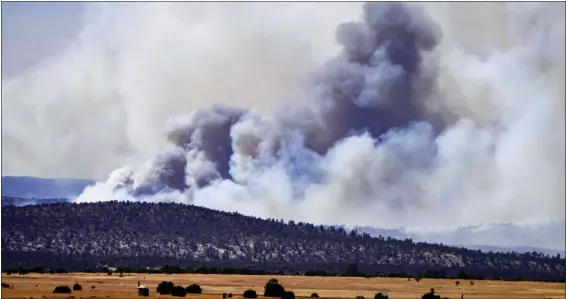  ?? ROBERTO E. ROSALES — THE ALBUQUERQU­E JOURNAL VIA AP ?? Smoke rises from wildfires near Las Vegas, N.M., May 4. Firefighte­rs slowed the advance of the largest wildfire in the U.S. as heavy winds relented Wednesday, while President Joe Biden approved a disaster declaratio­n that brings new financial resources to remote stretches of New Mexico devastated by fire since early April.