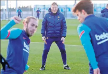  ??  ?? Koeman observa a Mingueza y Riqui Puig en un entrenamie­nto.