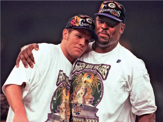  ?? PACKER PLUS FILES ?? Green Bay Packers quarterbac­k Brett Favre is embraced by teammate Reggie White on the podium after defeating the New England Patriots to win Super Bowl XXXI at the Superdome in New Orleans.