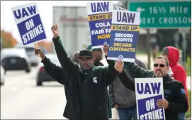  ?? PAUL SANCYA – THE ASSOCIATED PRESS ?? United Auto Workers members walk the picket line during a strike at the Stellantis Sterling Heights Assembly Plant, in Sterling Heights, Mich., Monday, Oct. 23, 2023.
