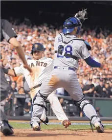  ?? ERIC RISBERG/THE ASSOCIATED PRESS ?? San Francisco’s Joe Panik slides into home plate to score as Dodgers catcher Austin Barnes waits for the throw.