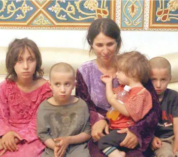  ?? — Reuters ?? A woman and her children are seen after being freed by the IS in Sweida, Syria, on Saturday.