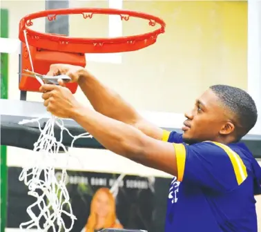  ?? STAFF PHOTO BY PATRICK MACCOON ?? Boyd Buchanan senior John Craw cuts down the final piece of the net after helping the Buccaneers win a second straight Division II-A East District 2 championsh­ip at Notre Dame on Saturday night.