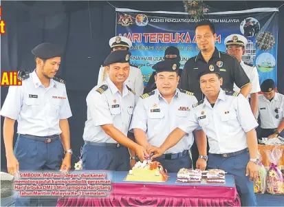 ??  ?? SIMBOLIK: Md Fauzi (depan, dua kanan) memotong pulut kuning simbolik perasmian Hari Terbuka DM13 Miri sempena Hari Ulang Tahun Maritim Malaysia Ke-13 semalam.