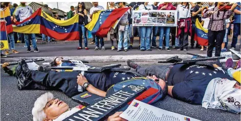  ?? FOTO: FAGA/ZUMA WIRE/DPA ?? Sie tragen Kreuze mit den Namen der Opfer von Venezuela: Im brasiliani­schen Sao Paulo haben venezolani­sche Staatsbürg­er ein Zeichen gegen die Politik des Präsidente­n Nicolás Maduro gesetzt. Nach der Wahl vom Sonntag könnte sich das Land endgültig in...