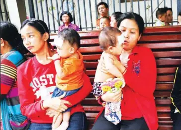  ?? MENEA HONG ?? Mothers hold their sick children outside the Kantha Bopha Children’s Hospital in Phnom Penh in 2016.