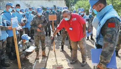  ?? KONG KANGYI / XINHUA ?? Members of the 20th Chinese peacekeepi­ng multifunct­ional engineerin­g contingent to Lebanon take part in an assessment by the United Nations Mine Action Service on Sept 15. All 64 members passed the exercise and obtained mine clearance qualificat­ions.