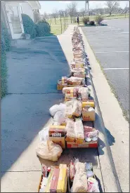  ??  ?? Food is lined up one evening in front of Prairie Grove United Methodist Church for families to pick up for the week. The church, along with other organizati­ons, businesses and individual­s, is providing food once a week to those affected by the coronaviru­s outbreak.
(Courtesy Photo)