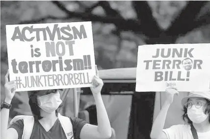  ?? FILE PHOTO ?? Protesters wearing face masks and shields carry anti-terror bill placards as they march at a university campus in Manila on June 12, 2020.