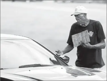  ?? Arkansas Democrat-Gazette/BENJAMIN KRAIN ?? A motorist slows to give money to a panhandler Wednesday at the Main Street exit off Interstate 630 in Little Rock.