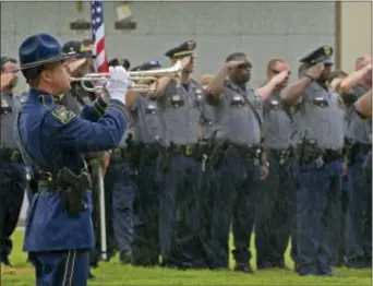  ?? HilARy SCHeiNUK — BAtON ROUGe ADVOCAte ViA AP ?? Members of the Baton Rouge Police Department salute as a member of the louisiana State Police Honor Guard, left, plays “taps” through driving rain during funeral services for Baton Rouge police Cpl. Montrell Jackson in Baton Rouge, la., Monday....
