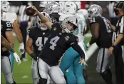  ?? STEVE MARCUS — THE ASSOCIATED PRESS ?? Raiders quarterbac­k Derek Carr (4) celebrates after scoring a touchdown against the Dolphins during the first half on Saturday in Las Vegas.