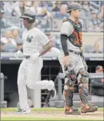  ?? Seth Wenig / Associated Press ?? The Yankees’ Andrew Mccutchen, left, scores a run past Baltimore catcher Austin Wynns on sunday.