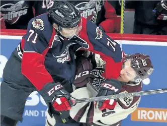  ?? JASON KRYK/POSTMEDIA NETWORK ?? Peterborou­gh Petes' John Parker-Jones is checked by Windsor Spitfires Lev Starikov during first-period Ontario Hockey League action at the WFCU Centre in Windsor on Thursday night. The Petes beat the defending Memorial Cup champions 5-1 to continue...