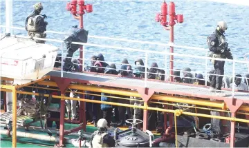  ?? — AFP photo ?? Army forces and migrants stand onboard Motor Tanker Elhibru 1 that was hijacked by migrants it had rescued off Libya, docked at Boiler Wharf in Valletta’s Grand Harbour, after Maltese armed forces took control of the vessel.