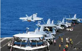  ?? —AFP ?? ‘HEAVY LIFTING’ An F/A-18E Super Hornet launches from the aircraft carrier USS Theodore Roosevelt somewhere in the South China Sea in this photo taken in April.