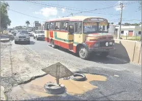  ??  ?? Un bus chatarra que todavía sigue en circulació­n, ayer en zona del metrobús, en donde surgió un gran bache.