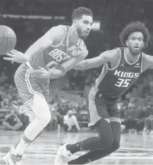  ?? CHARLES KRUPA/AP ?? Celtics forward Jayson Tatum (0) passes the ball while pressured by Kings forward Marvin Bagley III (35) during the first quarter Tuesday in Boston. Tatum scored 36 points in a 128-75 Celtics victory.