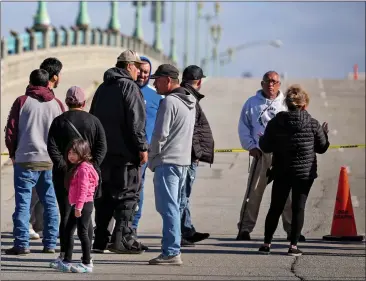  ?? RAY CHAVEZ — BAY AREA NEWS GROUP ?? Pajaro residents stand on the Main Street Bridge in Watsonvill­e as they wait to return home on Thursday. Until the evacuation order is lifted, Pajaro residents are unable to return home after evacuating from the floodwater­s last Saturday.