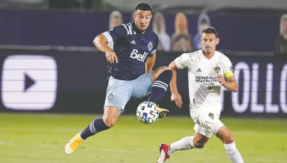  ?? KIRBY LEE/ USA TODAY SPORTS ?? Whitecaps forward Lucas Cavallini keeps the ball away from L.A, Galaxy defender Daniel Steres during the first half of Sunday's game in Carson, Calif.