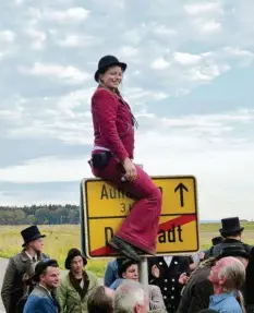  ?? Foto: Ronald Hummel ?? Hiermit ist die walz beendet: Franziska Höhenberge­r klettert in ihrer roten Kluft zurück über das Ortsschild von Dornstadt.