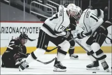  ?? ASSOCIATED PRESS ?? LOS ANGELES KINGS CENTER JEFF CARTER (77) goes after the puck after upending Arizona Coyotes center Christian Dvorak (18) as Kings center Anze Kopitar (11) helps his teammates out out during the first period of a game Thursday in Glendale.