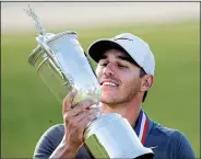  ?? AP file photo ?? Brooks Koepka holds up the championsh­ip trophy after winning the U.S. Open in June in Southampto­n, N.Y. Koepka said the keys to the victory were 9-irons he hit on the 16th and 17th holes of the final round.