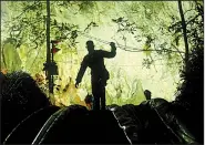  ?? AP/SAKCHAI LALIT ?? A rescuer makes his way down the entrance to a cave complex in Mae Sai, Thailand, on Monday, where 12 boys and their soccer coach were found after more than a week.