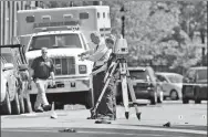  ?? MEL EVANS / ASSOCIATED PRESS ?? Investigat­ors stand in a street near evidence markers outside the warehouse building where a shooting happened on Sunday, in New Jersey.