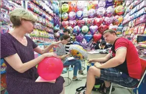  ?? LYU BING / FOR CHINA DAILY ?? Buyers from Russia check out balloon products at Yiwu Internatio­nal Commoditie­s Mall, Zhejiang province.