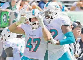  ?? CHARLES TRAINOR JR/MIAMI HERALD ?? Miami’s Kiko Alonso (47) and T.J. McDonald celebrate a fumble recovery against the New York Jets on Sunday. The Dolphins had three takeaways.