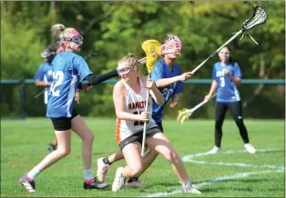  ?? KYLE FRANKO — TRENTONIAN PHOTO ?? Hamilton West’s Morgan Bressler (13) tries to move past two Burlington City players during a girls lacrosse game on Monday afternoon at Al Cowell Field in Hamilton Twp.