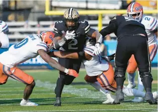  ?? MARK HUMPHREY/AP ?? Vanderbilt running back Ray Davis carries the ball as he is hit by Florida safety Trey Dean III in the second half Saturday in Nashville, Tenn.