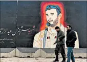  ?? PAMELA CONSTABLE/THE WASHINGTON POST ?? Pedestrian­s pass a mural Tuesday in Kabul of Gen. Abdul Raziq Achakzai, an Afghan hero who was killed in October.