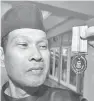  ?? — Gambar Bernama ?? PENGHARGAA­N: Zaidi menunjukka­n Pingat Gagah Perwira (PGP) yang diterimany­a sempena Ulang Tahun ke-80 Yang di-Pertua Negeri Pulau Pinang, Tun Abdul Rahman Abbas, di Dewan Sri Pinang dekat George Town, semalam.