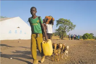  ?? Justin Lynch / Associated Press ?? Two South Sudanese boys arrive at a refugee center in Palorinya, Uganda. More than half a million people have fled since July as civil war continues amid warnings of genocide.