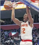  ?? Carlos Osorio / Associated Press ?? The Hawks’ De’andre Hunter dunks in the second half of Atlanta’s seasonopen­ing victory Thursday night at Detroit.