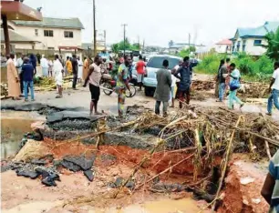  ??  ?? A portion of the road washed away by the flash floods in Obafemi-Owode LG, Ogun State