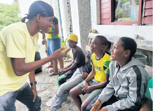  ?? PHOTO BY SHANNA MONTEITH ?? Jaheim Brown, 16, raps with one of the 28 students enrolled in his summer school programme in Yallahs, St Thomas. Students aged four to 23 attend the sessions.