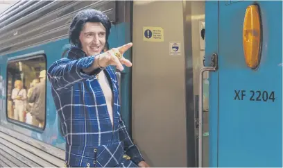  ?? Pictures: AFP ?? BLUE SUEDE EXPRESS. An Elvis Presley impersonat­or gestures at Central Station in Sydney yesterday as he boards a train to travel to the annual Elvis Festival in Parkes, Australia, yesterday.