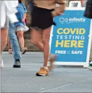  ?? Spencer Platt/Getty Images North America/TNS ?? People walk past a Covid testing site in New York City.