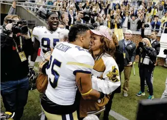 ?? DAVID GOLDMAN / ASSOCIATED PRESS ?? Tre’ Jackson proposes to DesiNathe in front of teammates, spectators and photograph­ers afterGeorg­ia Tech’s 28-22 upset victory over Virginia Tech last Saturday.