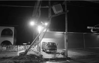  ??  ?? Een auto heeft een elektricit­eitsmast met trafo geramd aan de Anamoestra­at. De mast hing over de berm. (Action-foto: Shaylendra Jarbandhan)