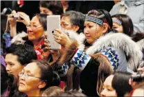  ?? CHRIS WATTIE / REUTERS ?? An Inuit woman takes a photo of the prime minister using a tablet during a community feast in Cambridge Bay, Nunavut this week.