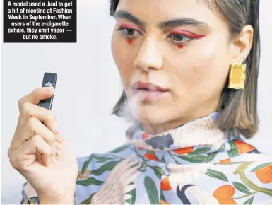  ??  ?? A model used a Juul to get a hit of nicotine at Fashion Week in September. When users of the e-cigarette exhale, they emit vapor — but no smoke.