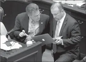  ?? Arkansas Democrat-Gazette/STEPHEN B. THORNTON ?? Rep. Charlie Collins (left) talks with Rep. Les Eaves, R-Searcy, during debate on the House floor Wednesday on Collins’ concealed-carry bill.