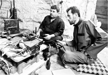  ?? — AFP photo ?? Syrian rebel fighters communicat­e through a radio as they prepare in anticipati­on of an attack by the regime on Idlib province and the surroundin­g countrysid­e, in Kafr Zeta.