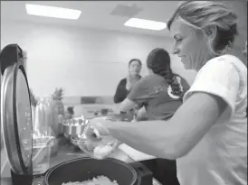  ??  ?? Jennifer Polhemus scoops rice at Loco Poke.